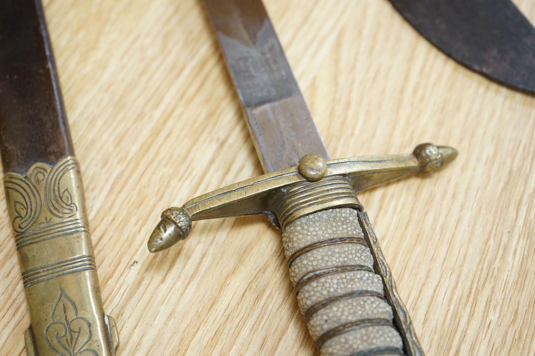 A post 1902 Naval Officer’s Dirk, the regulation blade with crowned fouled anchor, regulation hilt with remains of bullion dress knot in its leather scabbard with brass mounts, locket engraved with owners initials; RSA